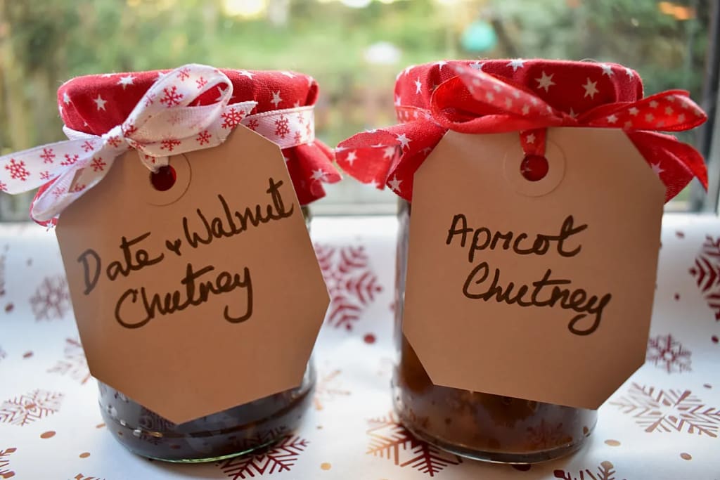 Two jars of Christmas chutney with labels and decorative lids.